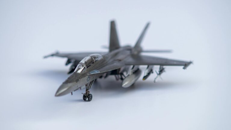 Detailed close-up of a miniature military fighter jet model on white background.