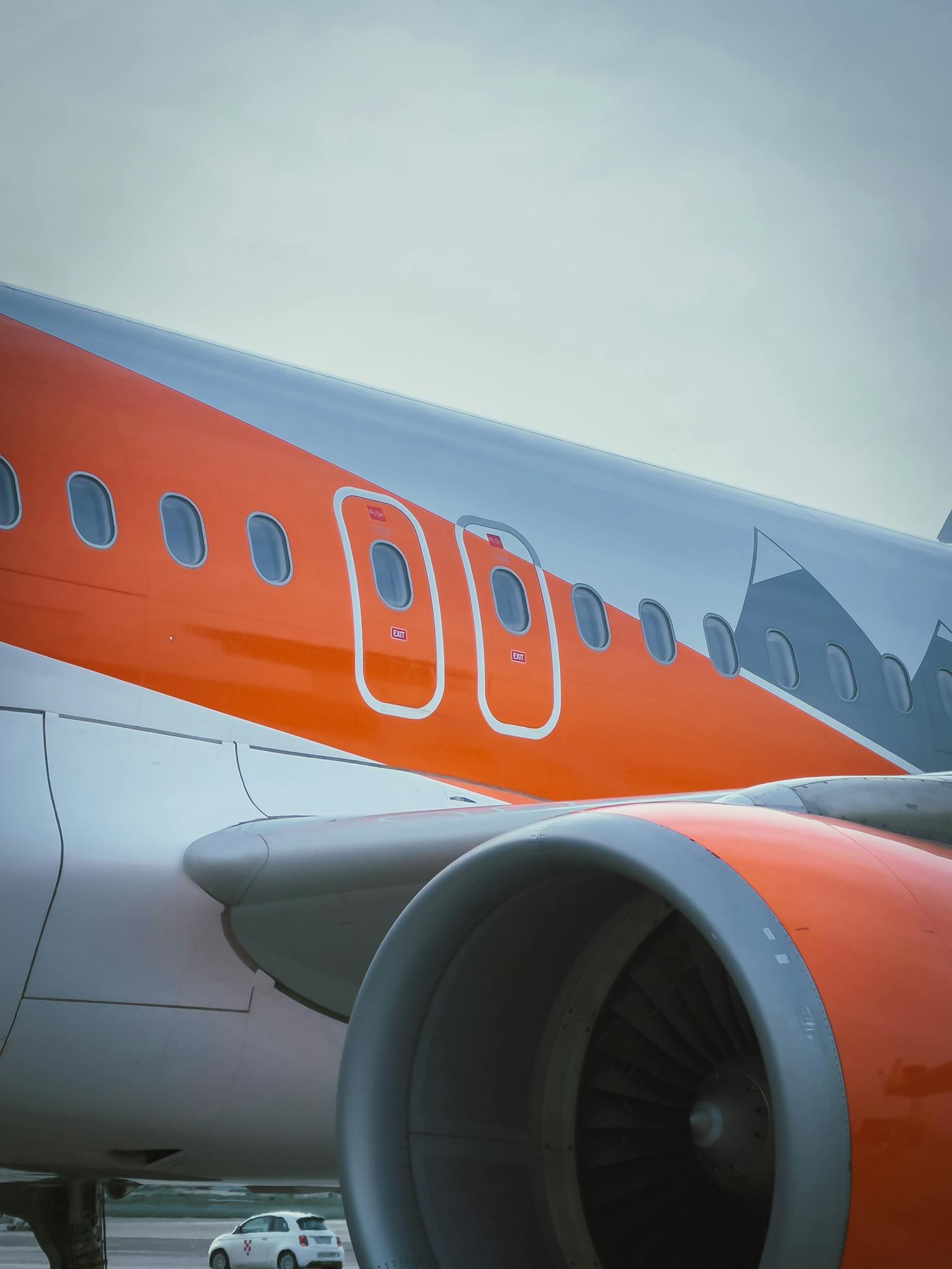 Detailed view of a commercial airplane wing and engine on a clear day.